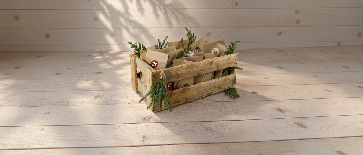 Schnaps- und Likör-Adventskalender der Brennerei Fink: Holzkiste mit nummerierten Kraftpapiertüten und Tannenzweigen